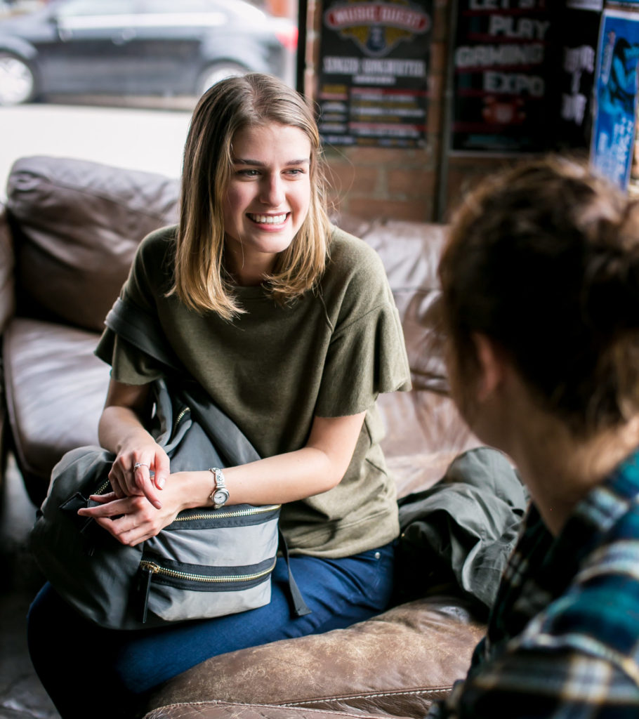 Two students chatting on a couch off campus.
