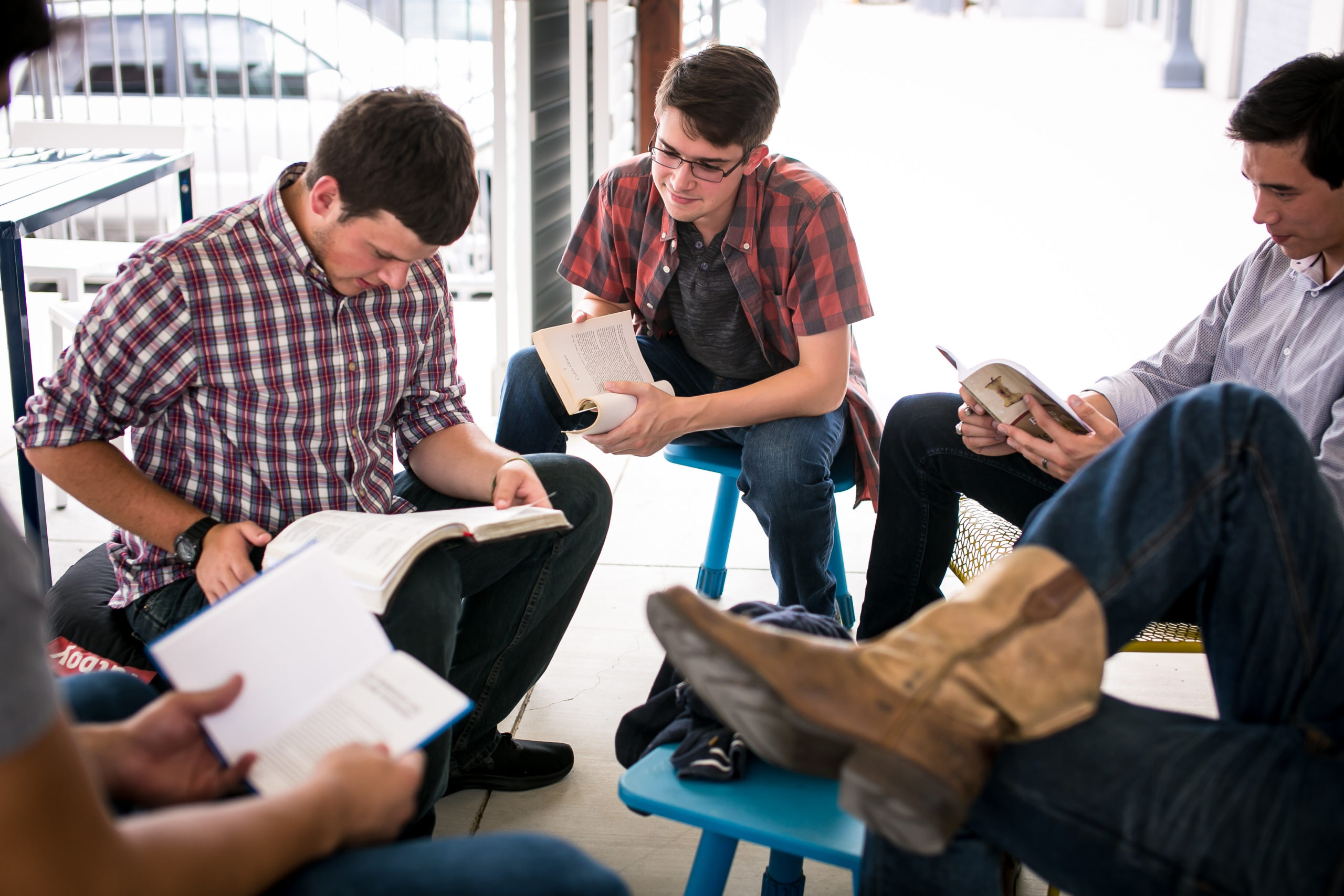 A small group of young men participating in a Bible study at a local establishment.